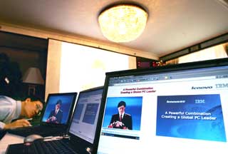 Computer screens show Yang Yuanqing, President and Chief Executive officer of Lenovo Group Ltd during a live feed news conference from Beijing in Hong Kong December 8, 2004. China's largest personal computer maker, Lenovo Group Ltd. , said on Wednesday it is buying control of IBM's PC-making business for US$1.25 billion, capping the U.S. tech giant's gradual withdrawal from the business it helped pioneer in 1981. The agreement, which forms the world's third largest PC business, calls for Lenovo to pay IBM $650 million in cash, $600 million in Lenovo Group common stock and for Lenovo to assume $500 million in net balance sheet liabilities from IBM.