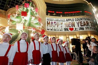 A children's choir sings after a Christmas tree made out of beer bottles was lit up yesterday night in front of Shanghai Times Square on Huaihai Road. The shopping mall will hold an countdown to the new year.
