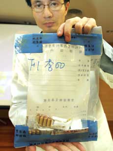 A police forensics expert holds up homemade bullets, manufactured by an underground arms factory, that were used in the election-eve shooting of Chen Shui-bian and Annette Lu on December 13, 2004. Tiawan police have arrested members of an underground group that made the bullets used in the election-eve shooting of Chen Shui-bian in March, a government investigator said on Monday. [Reuters]
