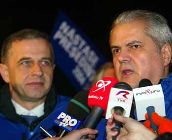 Romania's Prime Minister Adrian Nastase (R) speaks to the media as Foreign Minister Mircea Geoana (L) looks on after the first exit polls showing Nastase in a tie against centrist opponent Traian Basescu in the second round of the presidential elections in Bucharest, December 12, 2004. The update, which included votes cast in the remaining two hours of the vote, showed both rivals with 50 percent each. An earlier poll by state television also showed them running neck-and-neck. Official results are due on Monday. [Reuters]