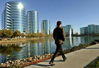 A man walks past the Oracle office in Redwood Shores, Calif., Monday, Dec. 13, 2004. Ending 18 months of bad blood, Oracle Corp. raised its takeover bid for bitter rival PeopleSoft Inc. by 10 percent to seal a $10.3 billion deal that will create the world's second largest maker of business applications software. The agreement, announced Monday, caps a rancorous Silicon Valley feud marked by churlish exchanges between the companies' management teams and colorful courtroom battles. 