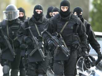 Greek police elite forces walk towards a hijacked bus on a street some 30 kilometres north of Athens December 15, 2004. 