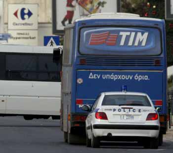 A police car is seen behind a hijacked bus on a street some 30 kilometres north of Athens December 15, 2004. Greek police forces surrounded the bus after two armed men hijacked it early Wednesday morning with 26 passengers on board on its way from northern Athens suburbs to the Greek capital. [Reuters]