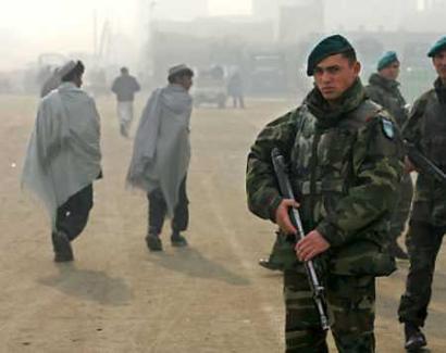 Turkish soldiers from the NATO-led International Security Assistance Force patrol as Afghans walk past in Kabul December 15, 2004. A Turkish engineer abducted by a militant gang in eastern Afghanistan was found dead on Wednesday, a witness who saw the body being carried down from a mountainside said. [Reuters]