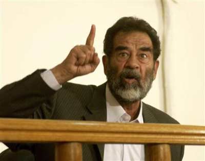 Saddam Hussein appears in a courtroom at Camp Victory, a former Saddam palace on the outskirts of Baghdad, Thursday, July 1, 2004. Downcast but defiant, Saddam questioned the judge's authority and saying the "real criminal" was U.S. President Bush. Saddam, who arrived at the courthouse in handcuffs and chains, was read seven charges under a preliminary arrest warrant and told his rights, pool reporters granted access to the heavily guarded proceedings said. [AP Photo]