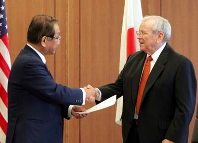 Japan's Defence Minister Yoshinori Ohno (L) shakes hands with the U.S. Ambassador to Japan Howard Baker at the Defence Ministry in Tokyo December 17, 2004. The two exchanged documents on bilateral technological co-operation on the missile defence system. [Reuters]