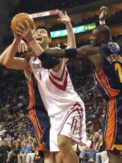 Houston Rockets center Yao Ming, center, of China, is double-teamed by Golden State Warriors Troy Murphy, left, and Mickael Pietrus (2), of France, in the first half Friday, Dec. 17, 2004, in Houston. Murphy was called for a foul on the play. [AP]