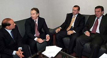 Italian Prime Minister Silvio Berluconi (L) British Prime Minister Tony Blair (2nd L) Turkish Prime Minister Tayyip Erdogan (2nd R) and German Chancellor Gerhard Schroeder talk together during a meeting in Brussels, December 17, 2004. EU leaders delayed the restart of a European Union summit on Friday for private consultations on Turkey, which has been offered entry talks provided it takes steps towards recognising the Greek Cypriot government. [Reuters]