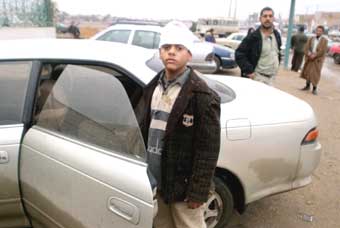 An Iraqi boy stands outside a hospital after being treated for injuries from a car bomb explosion near a mosque in Najaf, December 19, 2004. A suicide car bomb in Iraq's Shi'ite Muslim holy city of Najaf on Sunday killed 48 people and wounded at least 90, a hospital official said. Suicide bombers struck two of Iraq's holiest cities for Shi'ites on Sunday in seemingly coordinated attacks just six weeks before Iraqi's first free elections, which Shi'ites are expected to dominate.