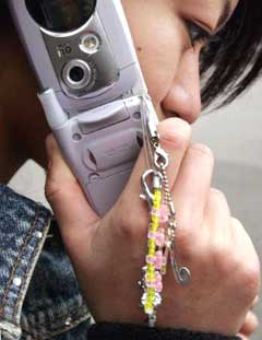 Fashion accessories dangle from a Japanese high school student's mobile phone in Tokyo December 19, 2004. For the average Japanese teenager, a cell phone is a must-have item, used for email, taking photos and keeping track of dates, in addition to the simple phone call. [Reuters]