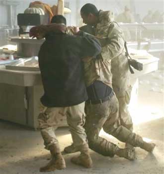 U.S. soldiers tend to the wounded after an apparent insurgent mortar attack on a dining facility during lunchtime on FOB Marez in Mosul, Iraq on Tuesday, Dec. 21, 2004. The attack killed 20. [AP]