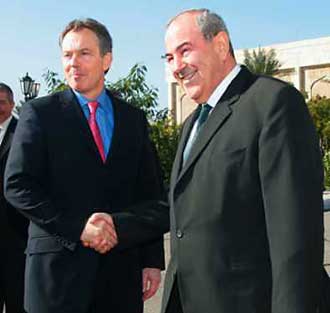 British Prime Minister Tony Blair (L) and Iraqi Prime Minister Iyad Allawi shake hands after reviewing an honor guard in Baghdad, December 21, 2004. Protected by U.S. Black Hawk helicopters, Blair flew into Baghdad Tuesday in a surprise show of political bravado designed to boost prospects for Iraqi elections in January. [Reuters] 
