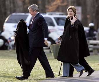 U.S. President George W. Bush and first lady Laura Bush walk to Marine One after a visit with wounded soldiers at Walter Reed Army Medical Center in Washington, December 21, 2004. The President and first lady were flying to Camp David where they will spend Chirstmas.