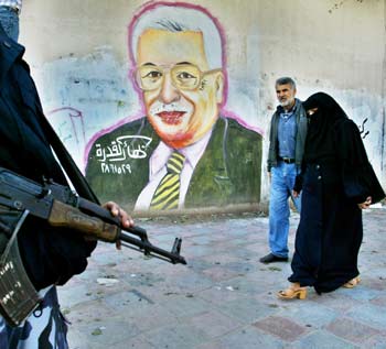 Palestinians pass a large mural of Palestinian presidential candidate Mahmoud Abbas in Gaza city December 26, 2004. Prominent Palestinian figures appealed on Sunday for an end to violence, adding weight to the election campaign of moderate Mahmoud Abbas to succeed Yasser Arafat and launch peace talks with Israel. [Reuters]