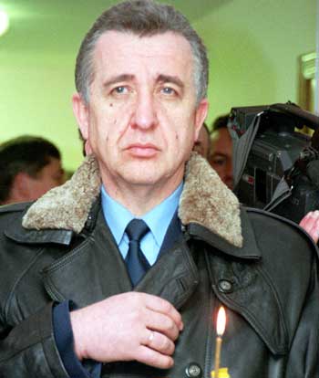Ukrainian transport minister Heorhiy Kyrpa makes the sign of the cross and holds a lit candle in Kiev. Ukrainian transport minister and one of Ukraine's most prominent businessmen was found dead December 27, 2004 at his home outside Kiev, a government source said. Picture taken January, 2001. [Reuters]