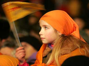 A young supporter of Ukrainian opposition leader Viktor Yushchenko, waves an orange campaign flag, as she takes part in a celebration rally in central Kiev, December 27, 2004. West-leaning Yushchenko looked certain on Monday to become Ukraine's next president, but his opponent Prime Minister Viktor Yanukovich refused to concede defeat. 