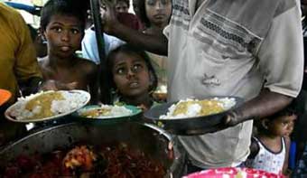 Children receive food in a refugee camp in Batagula, southern Sri Lanka on January 1, 2005. A legion of ships and planes delivered aid to millions of Asian tsunami survivors on Saturday as New Year celebrations around the world paused to mourn victims of one of the worst disasters in living memory that had killed 124,622 so far. [Reuters]
