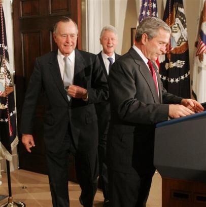 US President Bush, right, arrives in the Roosevelt Room at the White House to announce, Monday, Jan. 3, 2005, that he is appointing former Presidents George H.W. Bush, left, and Bill Clinton, center, to head up efforts to raise money for the massive American relief operation in the tsunami-battered regions. [AP]