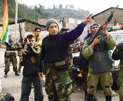 Former Army Major Antauro Humala (2nd L) gives orders to his armed followers as they continue their siege of a police station, in the southern Peru town of Andahuaylas, January 3, 2005. The armed group which took over a police station in southern Peru and killed four officers to demand the resignation of unpopular President Alejandro Toledo will not surrender on Monday as planned, Humala said. Humala, who has been holding ten officers hostage, said the government had broken another of the conditions he laid down for his surrender. [Reuters]