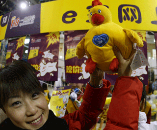 A student raises high a chicken-like doll at an offine sales hosted by online auction portal www.1pai.com.cn at the Renmin University of China in Beijing. [newsphoto]
