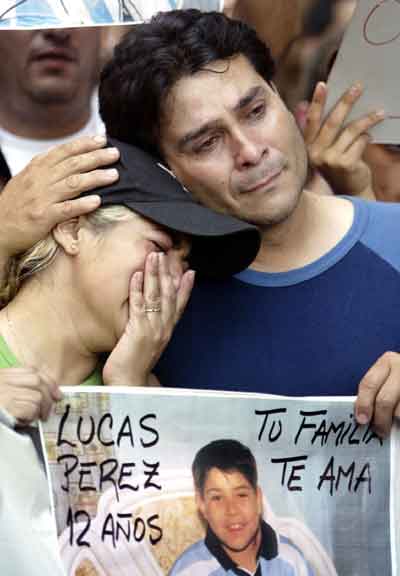 The parents of 12-year-old Lucas Perez, a boy killed in the December 30 nightclub fire, react during a demonstration in Buenos Aires, January 3, 2005. Relatives and friends held a protest to complain that authorities let the nightclub operate with locked emergency doors, inflammable soundproofing and dangerous overcrowding. Three days after a flare ignited the ceiling of the Cromagnon Republic club during a concert, the death toll rose to 183, adding to pressure on Buenos Aires City Hall to account for its role in one of Argentina's worst disasters. [Reuters]