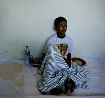 An Acehnese patient sits in the corridor of a hospital in the Indonesian provincial capital of Banda Aceh January 5, 2005. [Reuters]
