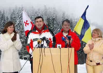 Ukrainian opposition leader Viktor Yushchenko (2nd R), his wife Kateryna Chymachenko (R) and wife of Georgian President Mikhail Saakashvili, Sandra Roelofs (L) applaud as Mikhail Saakashvili (2nd L) answers media questions during a news conference after skiing at the Carpathian mountains resort of Tysovets in Western Ukraine, January 5, 2005. Liberal Yushchenko, who defeated resigned Prime Minister Viktor Yanukovich in a December 26 rerun election, met reporters at a mountain retreat on Wednesday but gave no clues about plans to staff a new government. [Reuters]