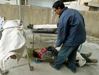 An Iraqi hospital worker covers the body of the brother of the deputy police chief of Baghdad after both of them were assassinated while travelling in Baghdad, early January 10, 2005. Gunmen assassinated Baghdad's deputy police chief Brigadier Amer Nayef and his brother on Monday as insurgents pressed a campaign to wreck Iraq's January 30 election, source said. [Reuters]