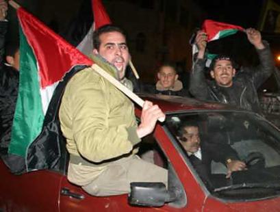 Supporters of Palestinian presidential candidate Mahmoud Abbas celebrate after the close of voting in the West Bank city of Ramallah, January 9, 2005. US President Bush praised Sunday's Palestinian elections as an essential step toward the goal of statehood and promised to help the new president, Mahmoud Abbas, in a renewed push for peace with Israel. [Reuters]