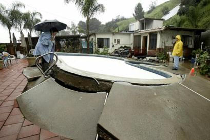 Josefina, left, and Frank Ramirez assess the condition of their swimming pool, damaged as a result of heavy rains, Monday, Jan. 10, 2005, in Monterey Park, California, the USA. [AP]