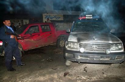 Iraqi police survey the scene after a car bomb explosion, late night Monday, Jan 10, 2005. Suicide attackers targeted an Interior Ministry office and a police station in the relatively quiet southern city of Basra on Monday night, wounding five policemen. (AP Photo/Nabil Al-Jurani) 