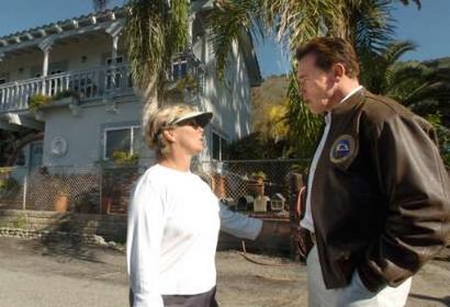 California Governor Arnold Schwarzennegger (R) talks to La Conchita, California resident Karen Oren who has lived in the seaside community for 36 years and asked the governor not to declare the area condemned, January 12, 2005. 10 people have died and six are still missing in the deadly mudslide. REUTERS/Tina Burch/Pool 