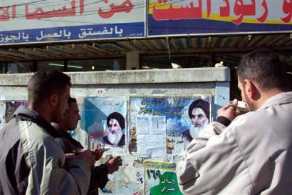 Iraqis have ther morning tea next to electoral posters featuring the Shiite cleric Ali al Sistani, in Baghdad, Thursday, Jan. 13, 2005. The election planned for Jan. 30 is the first democratic vote in Iraq since the country was formed in 1932. [AP]