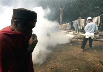 A refugee covers his face as a volunteer fumigates a refugee camp Thursday, Jan. 13, 2005 in Banda Aceh, Indonesia. As the threat of cholera diminished by the day because clean water is increasingly getting to tsunami survivors, the danger of malaria and dengue fever epidemics is now beginning to skyrocket, experts say. [AP]