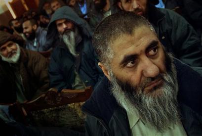 Afghan prisoners at the Supreme Court after leaving the main U.S. base at Bagram in Kabul Sunday January 16. 2005. The U.S. military on Sunday freed about 80 prisoners held in Afghanistan, a step which could help persuade supporters of the former Taliban government to give up their fight. [AP]