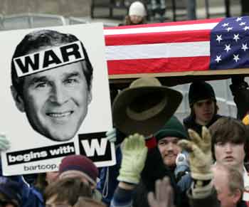 Protesters hold up a flag-draped coffin as U.S. President George W. Bush passes by during the inaugural parade in Washington, January 20, 2005. Flag-draped coffins and jeering anti-war protesters competed with pomp and circumstance on Thursday at the inauguration of President George W. Bush along the barricaded streets of central Washington. [Reuters]