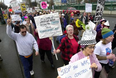 Protesters, many carrying signs and wearing homemade aluminum hats, walk through the streets of Portland, Ore., Thursday, Jan. 20, 2005, during a demonstration against the inauguration of US President Bush for his second term. [AP]