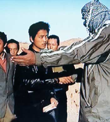 A video frame grab taken from a video released January 22, 2005 shows a Chinese hostage shaking hands with his captors in Iraq. Chinese embassy in Baghdad confirmed on Saturday the eight Chinese hostages have been freed. Insurgents holding eight Chinese labourers hostage in Iraq said on Saturday they were releasing the men, locals who saw the videotape circulated by the kidnappers said. The tape which surfaced in the western city of Ramadi said the hostages were being freed after China said it had advised its citizens not to travel to Iraq, locals said. [Reuters]