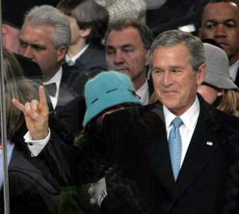 US President Bush gestures the ''Hook 'em, 'horns' salute of the University of Texas Longhorns as he and his family watch the Inaugural Parade Thursday Jan. 20, 2005, in Washington. President Bush's 'Hook 'em, 'horns' salute got lost in translation in Norway, where shocked people interpreted his hand gesture during his inauguration as a salute to Satan. [AP]