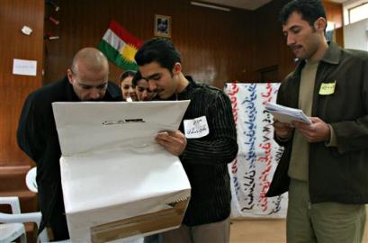 People examine a mock up ballot box during training for election monitors, in Arbil, Iraq Sunday, Jan. 23, 2005. [AP] 