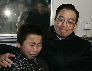 Premier Wen Jiabao consoles the son of former vice-chief-engineer of the col mine on January 2, 2005. His father died in the fatal accident. [Xinhua]