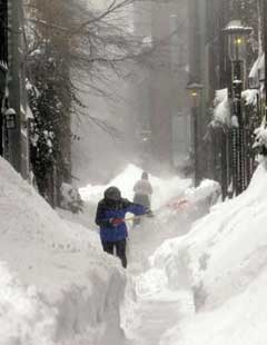 Residents dig out as a blizzard dumps some two feet of snow in the area, Sunday, Jan. 23, 2005, in Boston. Whiteout conditions grounded airplanes and sent fleets of plow and salt trucks trundling through snow-clogged roadways before the storm began to ebb at midday.(AP 