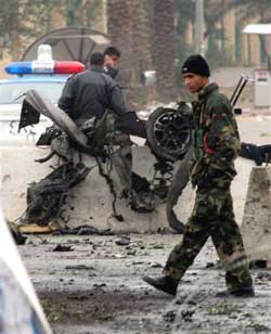 Iraqi police secure the area following a car bomb explosion in Baghdad, Monday, Jan 24, 2005. A suicide car bomber struck near the Iraqi interim prime minister's party headquarters Monday, injuring at least 10 people, police and hospital officials said. (AP 