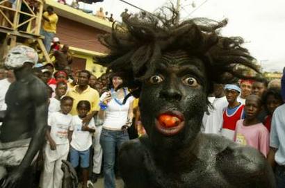 A carnival reveler covered with motor oil and wearing a wig tries to scare people during a procession at the traditional carnival celebrations in Jacmel, Haiti, January 30, 2005. Carnival is celebrated all over Haiti from February 6 through 8 except in Jacmel, which is a home to hundreds of artists. This year, the celebrations took place under the watchful eye of UN peacekeepers. [Reuters]