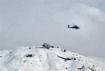 In this photo taken Saturday, February 5, 2005 by ISAF's AH-64 Apache helicopter and posted on the Web site of the International Security Assistance Force (ISAF), shows the crash site of a Kam Air Boeing 737 on the snow-capped mountain at Chaperi Ghar, Afghanistan. A NATO helicopter searching for an Afghan jetliner that disappeared during a snowstorm with 104 people aboard found what appears to be the wreckage of the plane Saturday February 5, 2005, in a area to the east of the Afghan capital, officials told the Associated Press. Officials believed none of the 96 passengers and eight - at least 24 of them foreigners - had survived, expected to be Afghanistan's deadliest. [AP]
