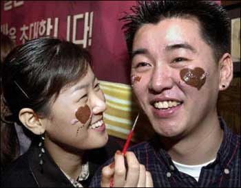A South Korean woman paints heart mark on her partner's face with chocolate during a face painting event for valentine's day in Soul last year. The concept of lovesickness might be more than just a flighty poetic notion, as it can burden the afflicted with genuine mental trauma, a British psychological study warned.(AFP