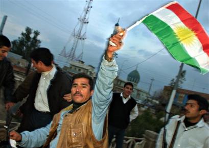 An unidentified Kurdish supporter waves a Kurdish flag as he runs through the streets despite a curfew, celebrating a strong electoral result for the Kurds, in Kirkuk, in the northern Kurdish area of Iraq Sunday, Feb. 13, 2005, after results for the Iraqi general election were announced. Iraq's majority Shiite Muslims won nearly half the votes in the nation's landmark Jan. 30 election, but will have to form a coalition in the 275-member National Assembly with the other top vote-getter - the Kurds and Prime Minister Ayad Allawi's list. [AP]