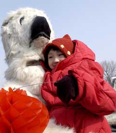 A child poses for a photo with a polar bear specimen in a park in Beijing February 16, 2005. Beijing university students displayed the specimen, likely to be victims of a global warming, to celebrate the Kyoto Protocol which enters into force on Wednesday. China signed the pact in May 1998 and ratified it in August 2002. Beijing students organized these activities to mark the great day in the global environmental protection history. [newsphoto]