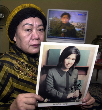 Metty Hafid, mother of freed Indonesian reporter Meutya shows her daughter's photo in Jakarta in front of a picture of fellow journalist Budiyanto. Two Indonesian journalists taken hostage in Iraq have been freed by their abductors, a member of the Sunni Muslim authorities in the Iraqi city of Ramadi say. [AFP/File]