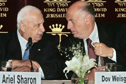 Israeli Prime Minister Ariel Sharon talks with senior adviser Dov Weisglass prior to his speech to the Conference of Presidents dinner in Jerusalem, Sunday, Feb. 20, 2005. Prime Minister Ariel Sharon's Cabinet on Sunday began charting Israel's future borders in a historic session, giving final approval to a withdrawal from the Gaza Strip and a revised route of the West Bank separation barrier that would encompass at least 6 percent of land claimed by the Palestinians for a state. [AP]